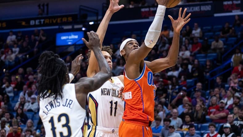 Mar 11, 2023; New Orleans, Louisiana, USA; Oklahoma City Thunder guard Shai Gilgeous-Alexander (2) drives to the basket against New Orleans Pelicans guard Dyson Daniels (11) and guard Kira Lewis Jr. (13) during the first half at Smoothie King Center. Mandatory Credit: Stephen Lew-USA TODAY Sports