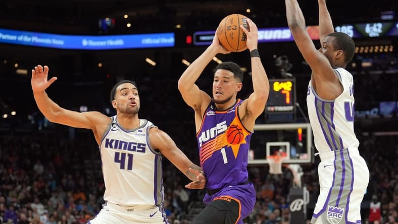 Mar 11, 2023; Phoenix, Arizona, USA; Phoenix Suns guard Devin Booker (1) drives against Sacramento Kings forward Trey Lyles (41) and Sacramento Kings forward Harrison Barnes (40) during the second half at Footprint Center. Mandatory Credit: Joe Camporeale-USA TODAY Sports