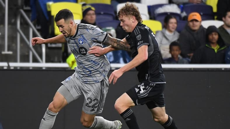 Mar 11, 2023; Nashville, Tennessee, USA; CF Montreal defender Aaron Herrera (22) and Nashville SC forward Jacob Shaffelburg (14) fights for the ball during the game at Geodis Park. Mandatory Credit: Christopher Hanewinckel-USA TODAY Sports