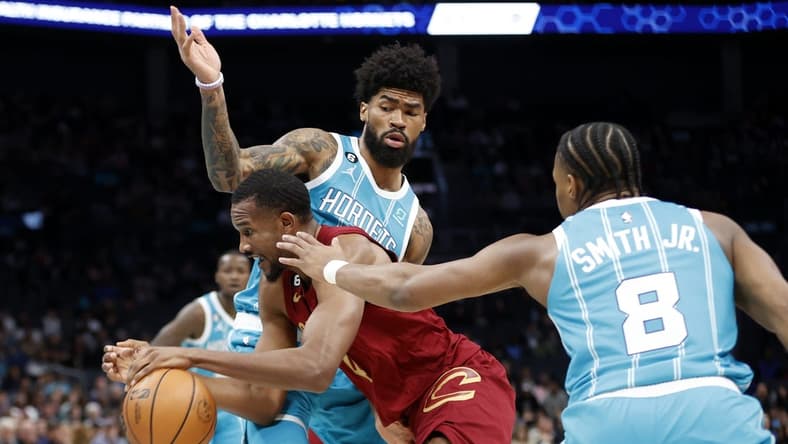 Mar 12, 2023; Charlotte, North Carolina, USA; Cleveland Cavaliers forward Evan Mobley (4) drives through Charlotte Hornets guard Dennis Smith Jr. (8) and center Nick Richards (4) during the first half at Spectrum Center. Mandatory Credit: Brian Westerholt-USA TODAY Sports