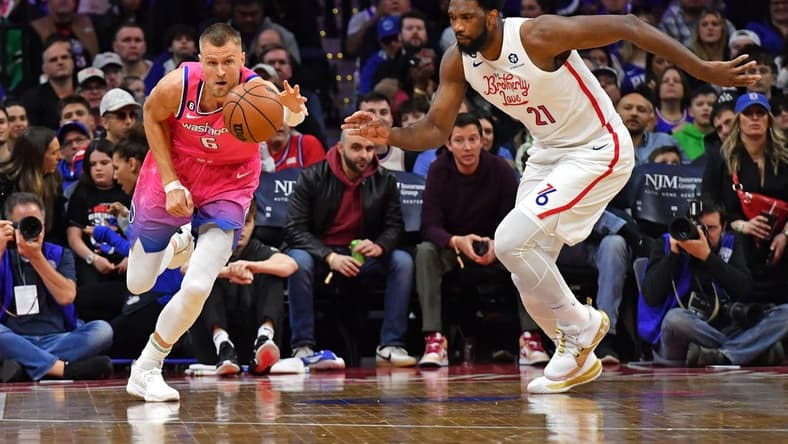 Mar 12, 2023; Philadelphia, Pennsylvania, USA; Washington Wizards center Kristaps Porzingis (6) and Philadelphia 76ers center Joel Embiid (21) chase after loose ball during the first quarter at Wells Fargo Center. Mandatory Credit: Eric Hartline-USA TODAY Sports