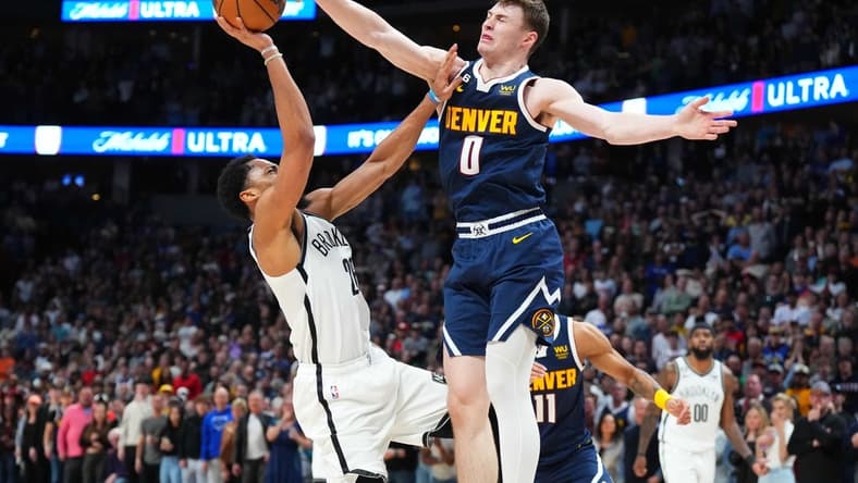 Mar 12, 2023; Denver, Colorado, USA; Denver Nuggets guard Christian Braun (0) blocks the shot of Brooklyn Nets guard Seth Curry (30) in the fourth quarter at Ball Arena. Mandatory Credit: Ron Chenoy-USA TODAY Sports