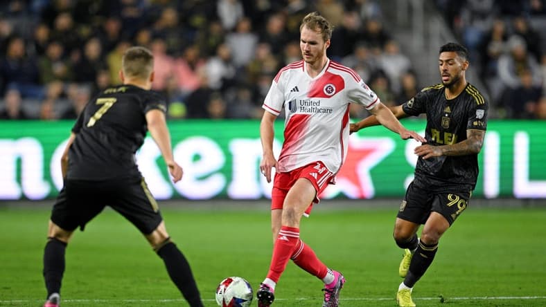 Mar 12, 2023; Los Angeles, California, USA; New England Revolution defender Henry Kessler (4) dribbles the ball against Los Angeles FC forward Stipe Biuk (7) and forward Denis Bouanga (99) during the first half at BMO Stadium. Mandatory Credit: Orlando Ramirez-USA TODAY Sports