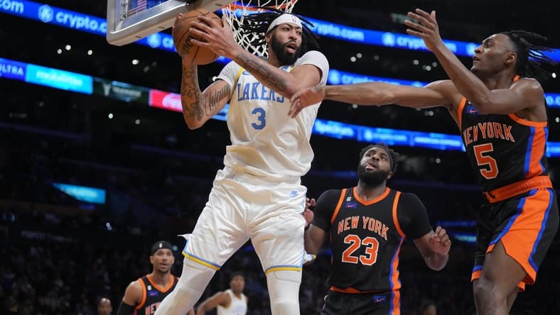 Mar 12, 2023; Los Angeles, California, USA; Los Angeles Lakers forward Anthony Davis (3) rebounds the ball against New York Knicks center Mitchell Robinson (23) and guard Immanuel Quickley (5) in the second half at Crypto.com Arena. Mandatory Credit: Kirby Lee-USA TODAY Sports