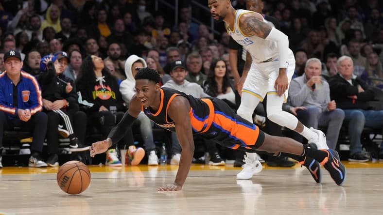 Mar 12, 2023; Los Angeles, California, USA; New York Knicks guard RJ Barrett (9) and Los Angeles Lakers guard D'Angelo Russell (1) reach for the ball in the second half at Crypto.com Arena. Mandatory Credit: Kirby Lee-USA TODAY Sports