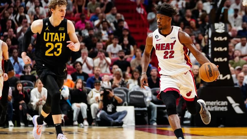 Mar 13, 2023; Miami, Florida, USA; Miami Heat forward Jimmy Butler (22) dribbles the ball past Utah Jazz forward Lauri Markkanen (23) during the fourth quarter at Miami-Dade Arena. Mandatory Credit: Rich Storry-USA TODAY Sports