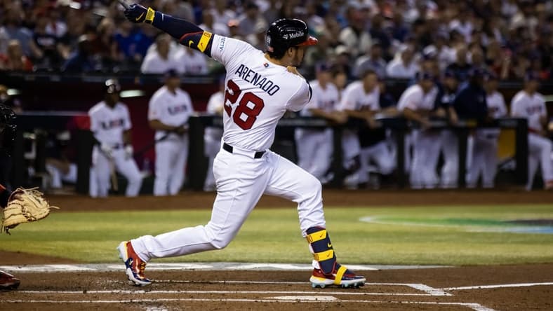 Mar 13, 2023; Phoenix, Arizona, USA; USA third baseman Nolan Arenado hits a two run double in the first inning against Canada during the World Baseball Classic at Chase Field. Mandatory Credit: Mark J. Rebilas-USA TODAY Sports