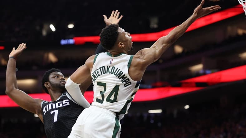 Mar 13, 2023; Sacramento, California, USA; Milwaukee Bucks power forward Giannis Antetokounmpo (34) scores a basket against Sacramento Kings power forward Chimezie Metu (7) during the third quarter at Golden 1 Center. Mandatory Credit: Kelley L Cox-USA TODAY Sports