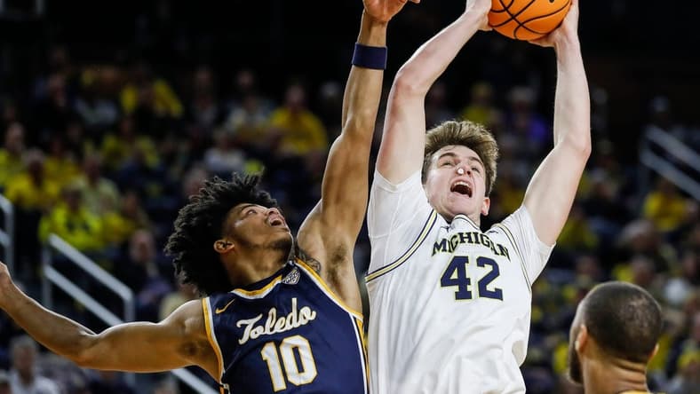 Michigan forward Will Tschetter (42) grabs a rebound against Toledo guard RayJ Dennis (10) during the first half of the first round of the NIT at Crisler Center in Ann Arbor on Tuesday, March 14, 2023.
