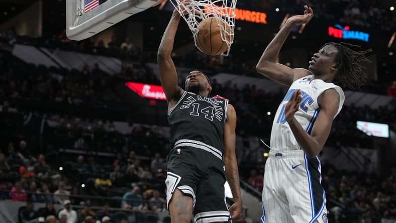 Mar 14, 2023; San Antonio, Texas, USA;  San Antonio Spurs guard Blake Wesley (14) dunks against Orlando Magic center Bol Bol (10) in the first half at the AT&T Center. Mandatory Credit: Daniel Dunn-USA TODAY Sports