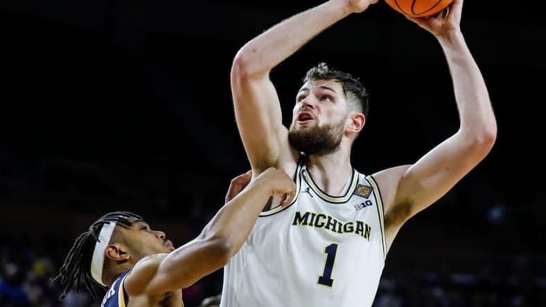 Michigan center Hunter Dickinson (1) goes to the basket against Toledo guard Dante Maddox Jr. (21) during the second half of the first round of the NIT at Crisler Center in Ann Arbor on Tuesday, March 14, 2023.