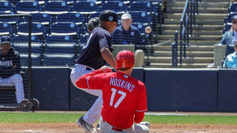 Mar 15, 2023; Tampa, Florida, USA; Philadelphia Phillies first baseman Rhys Hoskins (17) steals home plate in front of New York Yankees pitcher Carlos Gomez (33) during the first inning at George M. Steinbrenner Field. Mandatory Credit: Mike Watters-USA TODAY Sports