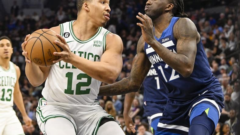 Mar 15, 2023; Minneapolis, Minnesota, USA;  Boston Celtics forward Grant Williams (12) protects the ball from Minnesota Timberwolves forward Taurean Prince (12) in the first quarter at Target Center. Mandatory Credit: Nick Wosika-USA TODAY Sports