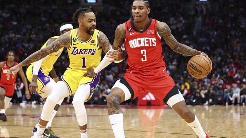 Mar 15, 2023; Houston, Texas, USA; Houston Rockets guard Kevin Porter Jr. (3) controls the ball as Los Angeles Lakers guard D'Angelo Russell (1) defends during the second quarter at Toyota Center. Mandatory Credit: Troy Taormina-USA TODAY Sports