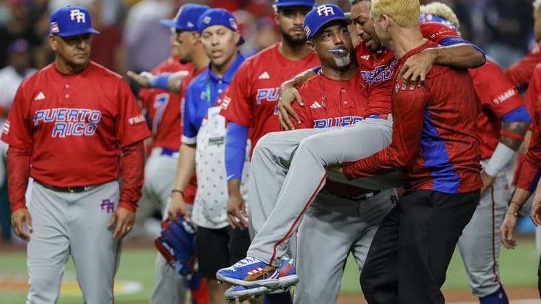 Mar 15, 2023; Miami, Florida, USA; Puerto Rico pitcher Edwin Diaz (39) gets taken off the field by pitching coach Ricky Bones (27) after an apparent leg injury during the team celebration against Dominican Republic at LoanDepot Park. Mandatory Credit: Sam Navarro-USA TODAY Sports