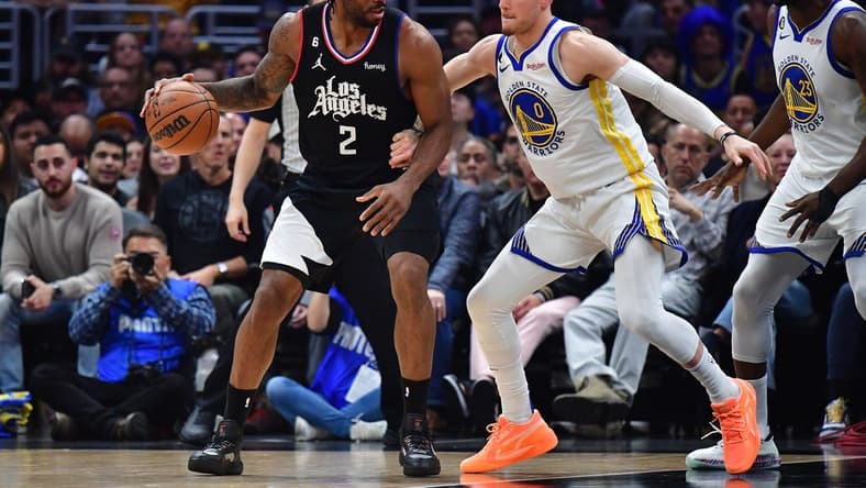 Mar 15, 2023; Los Angeles, California, USA; Los Angeles Clippers forward Kawhi Leonard (2) moves the ball against Golden State Warriors guard Donte DiVincenzo (0) during the first half at Crypto.com Arena. Mandatory Credit: Gary A. Vasquez-USA TODAY Sports