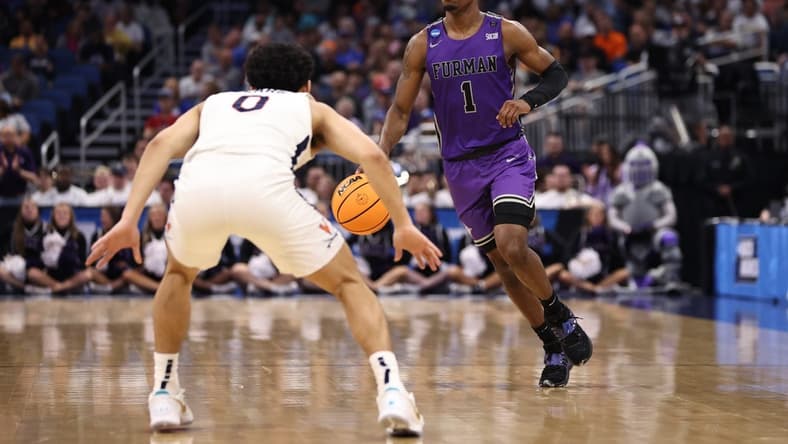 Mar 16, 2023; Orlando, FL, USA; Furman Paladins guard JP Pegues (1) dribbles the ball while defended by Virginia Cavaliers guard Kihei Clark (0) during the first half at Amway Center. Mandatory Credit: Matt Pendleton-USA TODAY Sports