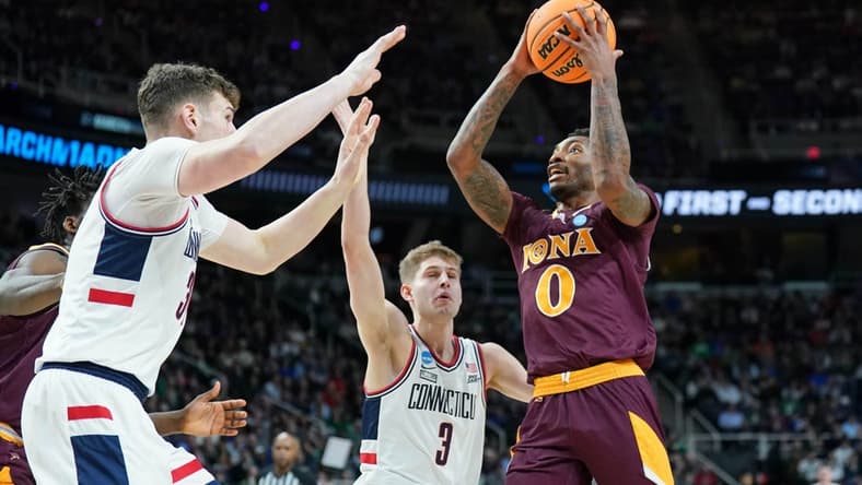 Mar 17, 2023; Albany, NY, USA; Iona Gaels guard Berrick JeanLouis (0) drives to the basket against UConn Huskies center Donovan Clingan (32) and guard Joey Calcaterra (3) during the first half at MVP Arena. Mandatory Credit: David Butler II-USA TODAY Sports
