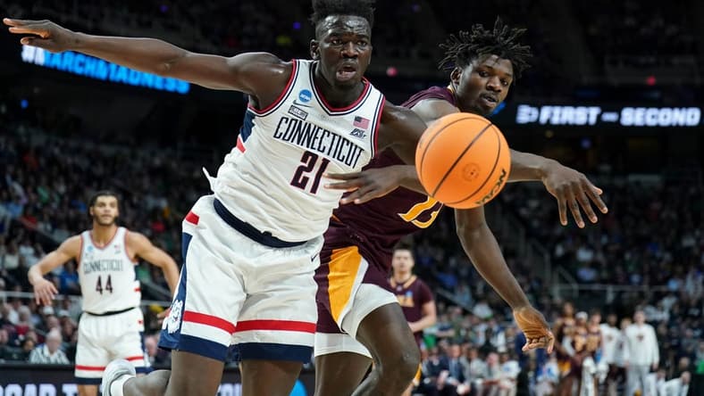 Mar 17, 2023; Albany, NY, USA; Iona Gaels forward Nelly Junior Joseph (13) reaches for the ball against UConn Huskies forward Adama Sanogo (21) during the first half at MVP Arena. Mandatory Credit: David Butler II-USA TODAY Sports
