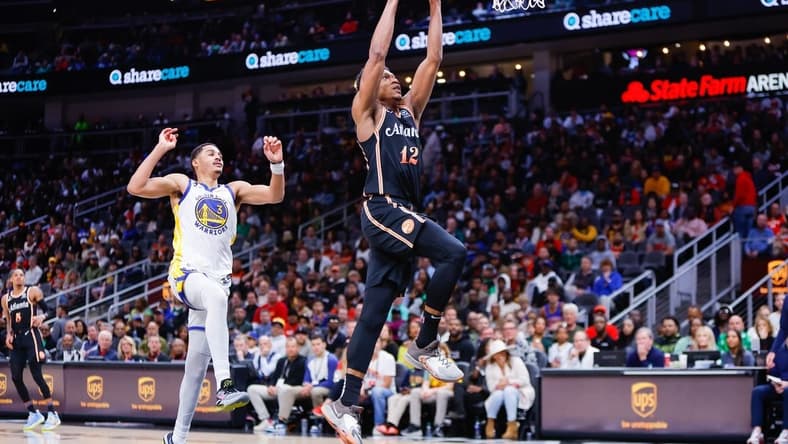 Mar 17, 2023; Atlanta, Georgia, USA; Atlanta Hawks forward De'Andre Hunter (12) dunks past Golden State Warriors guard Jordan Poole (3) in the second quarter at State Farm Arena. Mandatory Credit: Brett Davis-USA TODAY Sports