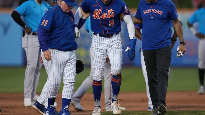Mar 17, 2023; Port St. Lucie, Florida, USA;  New York Mets center fielder Brandon Nimmo (9) walks back to the dugout with the assistance of manager Buck Showalter (11) and a trainer in the fifth inning against the Miami Marlins at Clover Park. Mandatory Credit: Jim Rassol-USA TODAY Sports