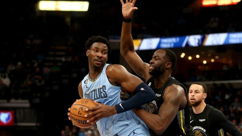 Mar 18, 2023; Memphis, Tennessee, USA; Memphis Grizzlies forward Jaren Jackson Jr. (13) spins toward the basket as Golden State Warriors forward Draymond Green (23) defends during the first half at FedExForum. Mandatory Credit: Petre Thomas-USA TODAY Sports