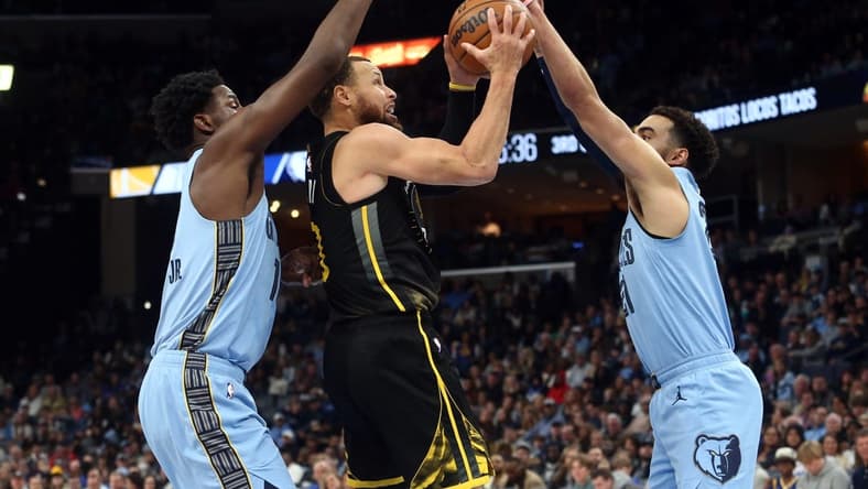 Mar 18, 2023; Memphis, Tennessee, USA; Golden State Warriors guard Stephen Curry (30) drives to the basket between Memphis Grizzlies forward Jaren Jackson Jr. (13) and guard Tyus Jones (21) during the second half at FedExForum. Mandatory Credit: Petre Thomas-USA TODAY Sports