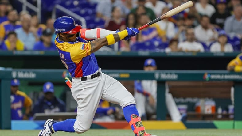 Mar 18, 2023; Miami, Florida, USA; Venezuela center fielder Ronald Acuna Jr. (42) hits a double during the eighth inning against the USA at LoanDepot Park. Mandatory Credit: Sam Navarro-USA TODAY Sports