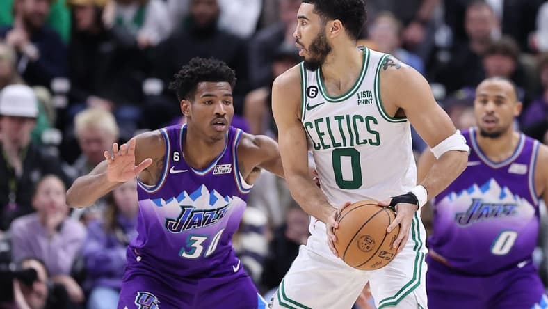 Mar 18, 2023; Salt Lake City, Utah, USA; Boston Celtics forward Jayson Tatum (0) posts up against Utah Jazz guard Ochai Agbaji (30) in the fourth quarter at Vivint Arena. Mandatory Credit: Rob Gray-USA TODAY Sports