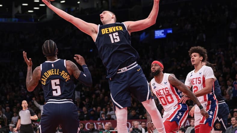 Mar 19, 2023; Brooklyn, New York, USA; Denver Nuggets center Nikola Jokic (15) rebounds in front of guard Kentavious Caldwell-Pope (5) and Brooklyn Nets forward Royce O'Neale (00) and forward Cameron Johnson (2) during the second half at Barclays Center. Mandatory Credit: Vincent Carchietta-USA TODAY Sports