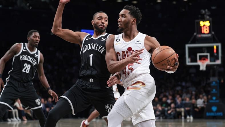 Mar 21, 2023; Brooklyn, New York, USA; Cleveland Cavaliers guard Donovan Mitchell (45) dribbles against Brooklyn Nets forward Mikal Bridges (1) during the first quarter at Barclays Center. Mandatory Credit: Vincent Carchietta-USA TODAY Sports