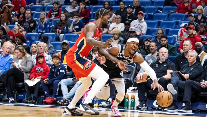 Mar 21, 2023; New Orleans, Louisiana, USA;  San Antonio Spurs guard Devonte' Graham (4) dribbles against New Orleans Pelicans forward Naji Marshall (8) during the first half at Smoothie King Center. Mandatory Credit: Stephen Lew-USA TODAY Sports