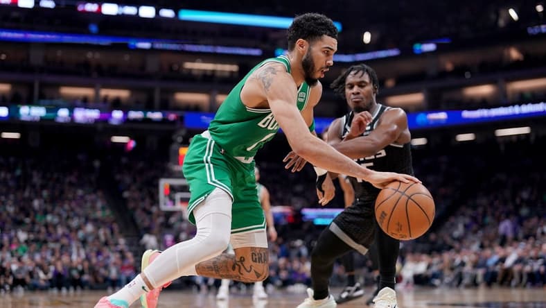 Mar 21, 2023; Sacramento, California, USA; Boston Celtics forward Jayson Tatum (0) dribbles past Sacramento Kings guard Davion Mitchell (15) in the second quarter at the Golden 1 Center. Mandatory Credit: Cary Edmondson-USA TODAY Sports