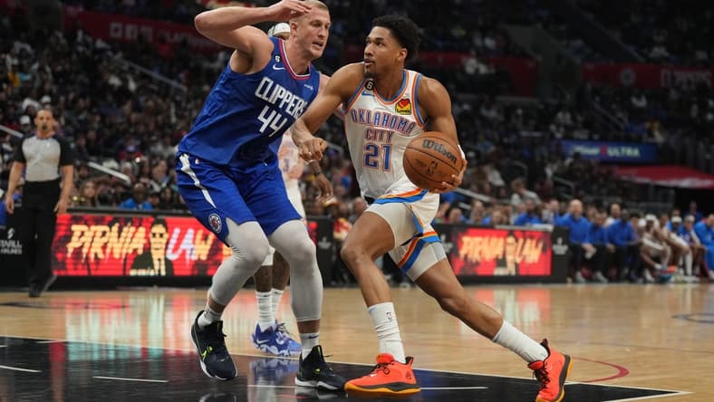 Mar 21, 2023; Los Angeles, California, USA; Oklahoma City Thunder guard Aaron Wiggins (21) dribbles the ball against LA Clippers center Mason Plumlee (44) in the second half at Crypto.com Arena. Mandatory Credit: Kirby Lee-USA TODAY Sports