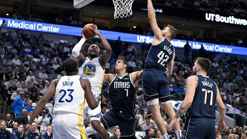 Mar 22, 2023; Dallas, Texas, USA; Golden State Warriors forward Kevon Looney (5) shoots over Dallas Mavericks center Dwight Powell (7) and forward Maxi Kleber (42) and guard Luka Doncic (77) during the first quarter at the American Airlines Center. Mandatory Credit: Jerome Miron-USA TODAY Sports