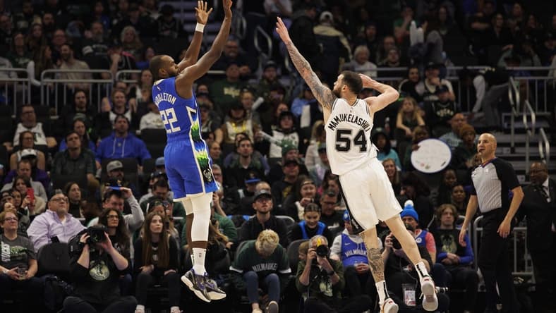 Mar 22, 2023; Milwaukee, Wisconsin, USA; Milwaukee Bucks forward Khris Middleton (22) shoots against San Antonio Spurs forward Sandro Mamukelashvili (54) during the fourth quarter at Fiserv Forum. Mandatory Credit: Jeff Hanisch-USA TODAY Sports