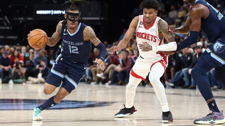 Mar 22, 2023; Memphis, Tennessee, USA; Memphis Grizzlies guard Ja Morant (12) drives to the basket as Houston Rockets guard Jalen Green (4) defends during the second half at FedExForum. Mandatory Credit: Petre Thomas-USA TODAY Sports