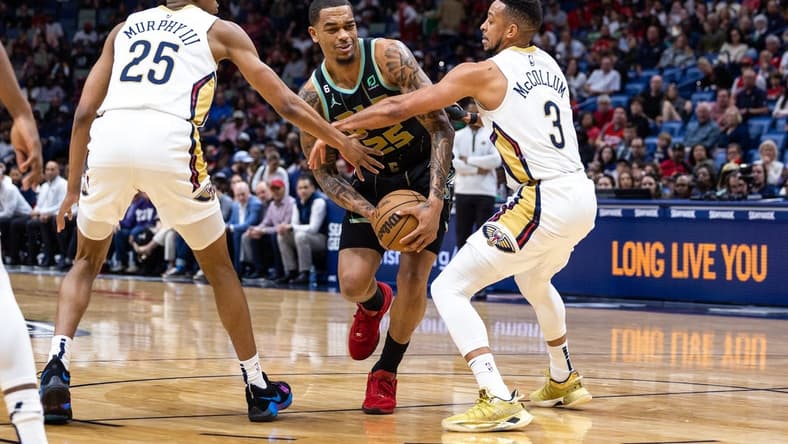 Mar 23, 2023; New Orleans, Louisiana, USA;  Charlotte Hornets forward P.J. Washington (25) is fouled by New Orleans Pelicans guard Trey Murphy III (25) and guard CJ McCollum (3) during the first half at Smoothie King Center. Mandatory Credit: Stephen Lew-USA TODAY Sports