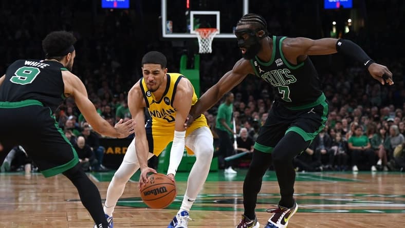 Mar 24, 2023; Boston, Massachusetts, USA;  Indiana Pacers guard Tyrese Haliburton (0) controls the ball while Boston Celtics guard Derrick White (9) and guard Jaylen Brown (7) defend during the first half at TD Garden. Mandatory Credit: Bob DeChiara-USA TODAY Sports