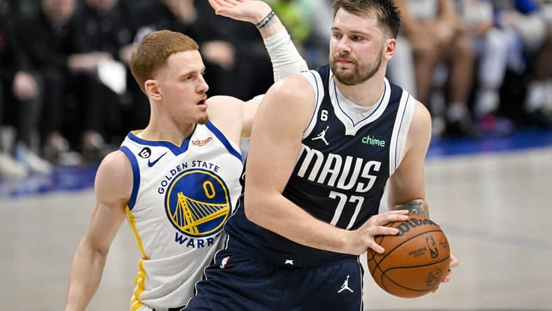 Mar 22, 2023; Dallas, Texas, USA; Golden State Warriors guard Donte DiVincenzo (0) and Dallas Mavericks guard Luka Doncic (77) in action during the game between the Dallas Mavericks and the Golden State Warriors at the American Airlines Center. Mandatory Credit: Jerome Miron-USA TODAY Sports