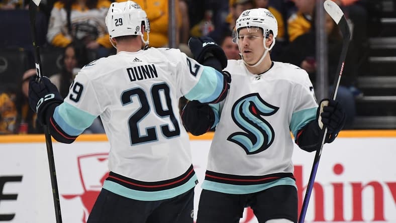 Mar 25, 2023; Nashville, Tennessee, USA; Seattle Kraken right wing Eeli Tolvanen (20) celebrates with defenseman Vince Dunn (29) after a goal during the first period against the Nashville Predators at Bridgestone Arena. Mandatory Credit: Christopher Hanewinckel-USA TODAY Sports