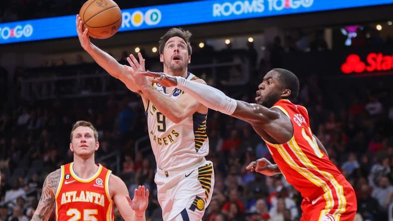 Mar 25, 2023; Atlanta, Georgia, USA; Indiana Pacers guard T.J. McConnell (9) shoots past Atlanta Hawks forward AJ Griffin (14) in the second quarter at State Farm Arena. Mandatory Credit: Brett Davis-USA TODAY Sports