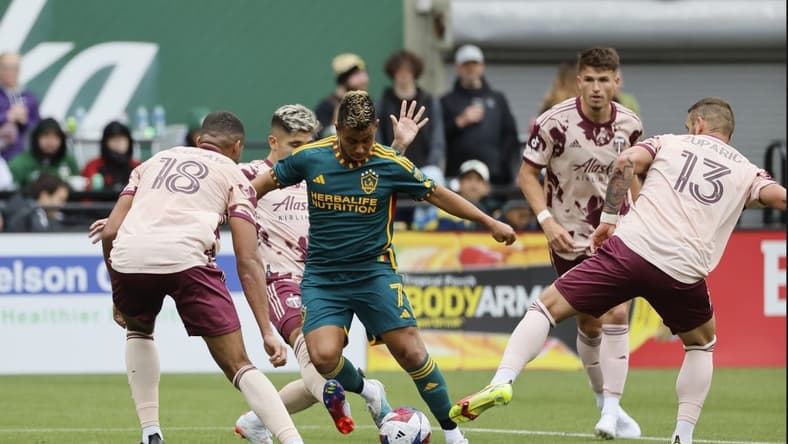 Mar 25, 2023; Portland, Oregon, USA; LA Galaxy midfielder Efrain Alvarez (7) controls the ball against Portland Timbers defender Zac McGraw (18) and Dario Zuparic (13) during the second half at Providence Park. Mandatory Credit: Soobum Im-USA TODAY Sports