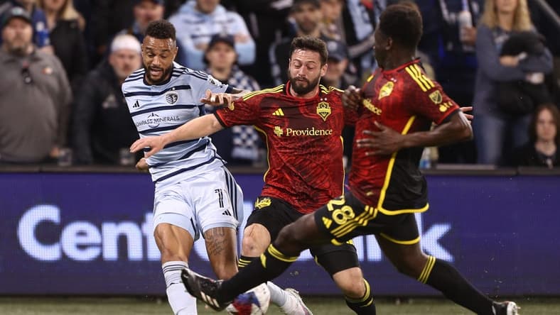 Mar 25, 2023; Kansas City, Kansas, USA; Sporting Kansas City forward Khiry Shelton (11) is defended by Seattle Sounders midfielder Joao Paulo (6) and Seattle Sounders defender Yeimar Gomez (28) in the first half at Children's Mercy Park. Mandatory Credit: William Purnell-USA TODAY Sports