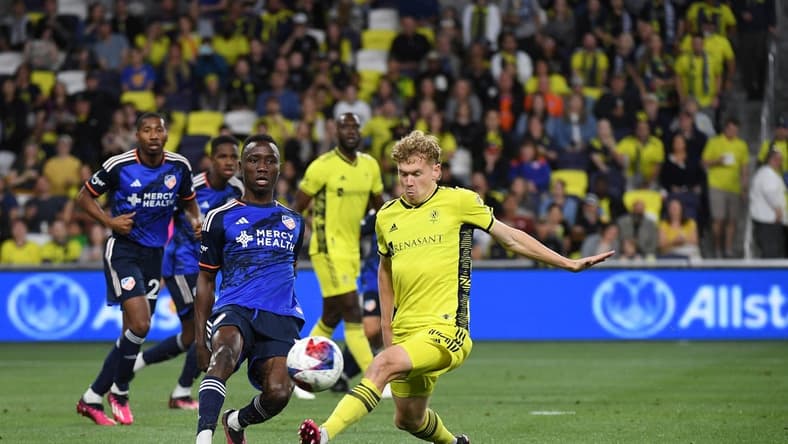 Mar 25, 2023; Nashville, Tennessee, USA; FC Cincinnati midfielder Obinna Nwobodo (5) passes the ball against Nashville SC forward Jacob Shaffelburg (14) at Geodis Park. Mandatory Credit: Christopher Hanewinckel-USA TODAY Sports