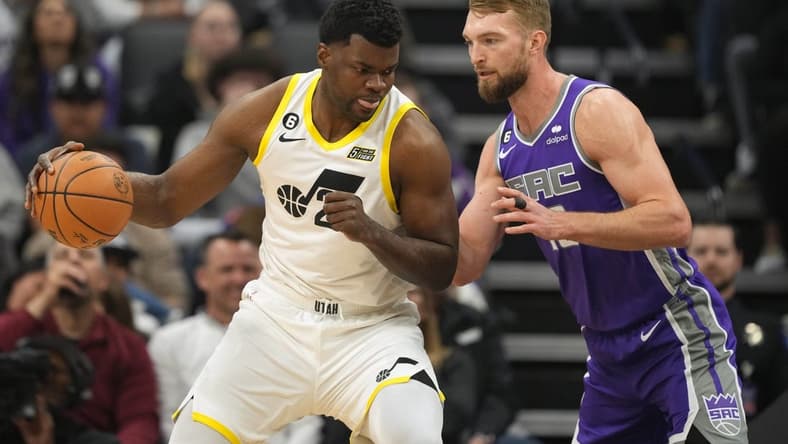 Mar 25, 2023; Sacramento, California, USA; Utah Jazz center Udoka Azubuike (left) dribbles against Sacramento Kings forward Domantas Sabonis (right) during the first quarter at Golden 1 Center. Mandatory Credit: Darren Yamashita-USA TODAY Sports