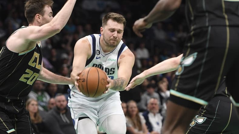 Mar 26, 2023; Charlotte, North Carolina, USA; Dallas Mavericks guard Luka Doncic (77) drives past Charlotte Hornets forward Gordon Hayward (20) during the first half at the Spectrum Center. Mandatory Credit: Sam Sharpe-USA TODAY Sports