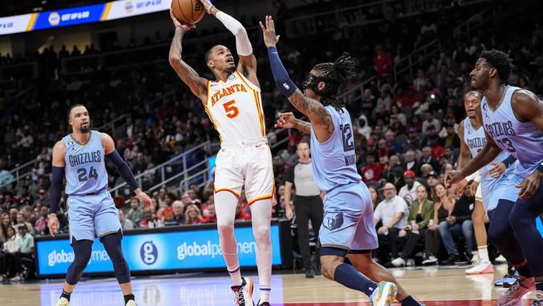 Mar 26, 2023; Atlanta, Georgia, USA; Atlanta Hawks guard Dejounte Murray (5) looks to shoot against Memphis Grizzlies guard Ja Morant (12) during the first half at State Farm Arena. Mandatory Credit: Dale Zanine-USA TODAY Sports