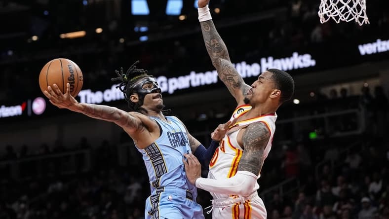 Mar 26, 2023; Atlanta, Georgia, USA; Memphis Grizzlies guard Ja Morant (12) goes to the basket against Atlanta Hawks forward John Collins (20) during the second half at State Farm Arena. Mandatory Credit: Dale Zanine-USA TODAY Sports