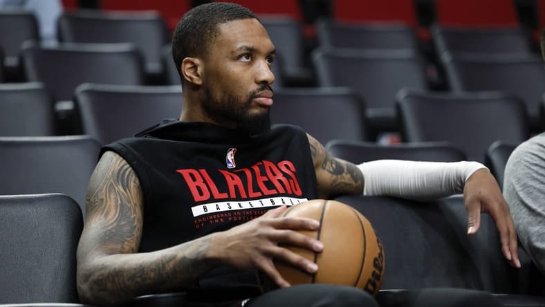 Mar 27, 2023; Portland, Oregon, USA; Portland Trail Blazers point guard Damian Lillard (0) watches players warm up prior to the game against the New Orleans Pelicans at Moda Center. Mandatory Credit: Soobum Im-USA TODAY Sports